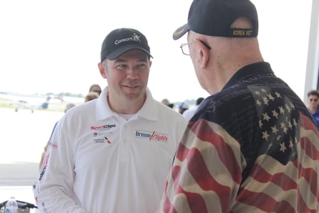 Brad Schnell speaks with a Veteran Flier, as they get ready for their turn to ride.